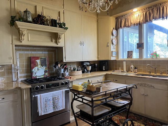 kitchen with tasteful backsplash, sink, high end range, and an inviting chandelier