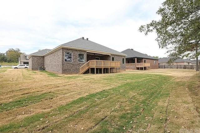 back of house with a wooden deck and a lawn