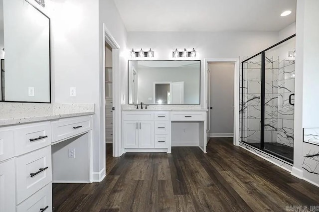 bathroom with hardwood / wood-style flooring, vanity, and walk in shower