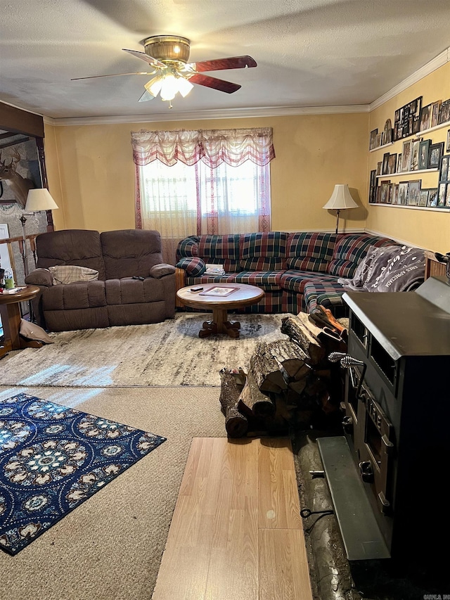 carpeted living room featuring a textured ceiling, ceiling fan, and ornamental molding