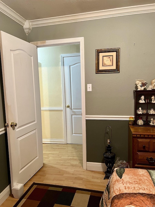 unfurnished bedroom featuring crown molding and hardwood / wood-style flooring