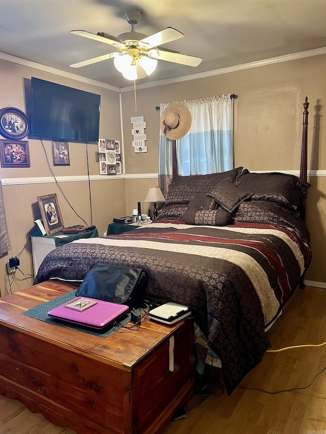 bedroom featuring hardwood / wood-style flooring, ceiling fan, and ornamental molding