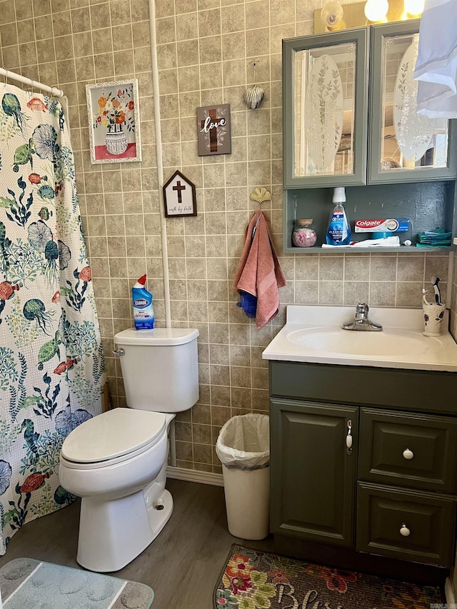 bathroom featuring vanity, hardwood / wood-style flooring, toilet, tile walls, and tasteful backsplash