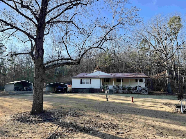 single story home featuring a front lawn, covered porch, and a carport