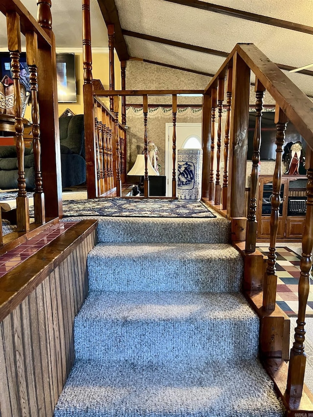 stairway with vaulted ceiling with beams