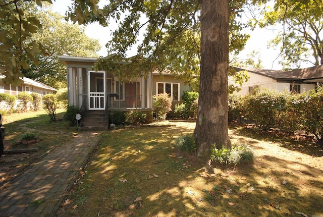 view of front facade featuring a front lawn and a sunroom