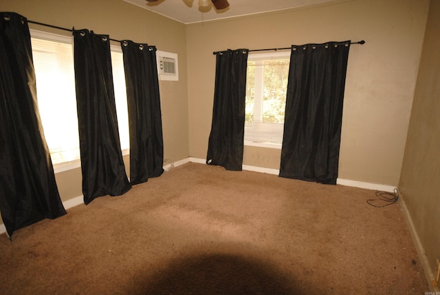 carpeted empty room featuring a wall unit AC and ceiling fan