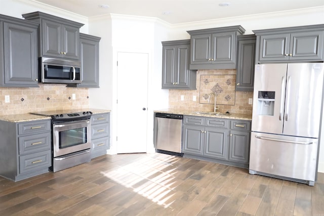 kitchen with light stone countertops, sink, appliances with stainless steel finishes, and tasteful backsplash