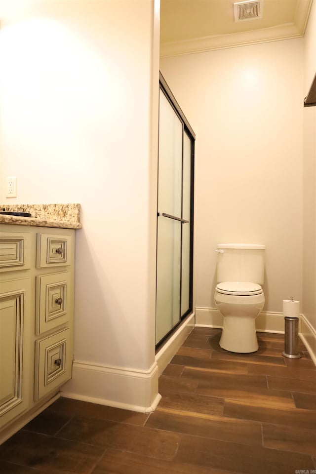 bathroom with crown molding, wood-type flooring, an enclosed shower, and toilet