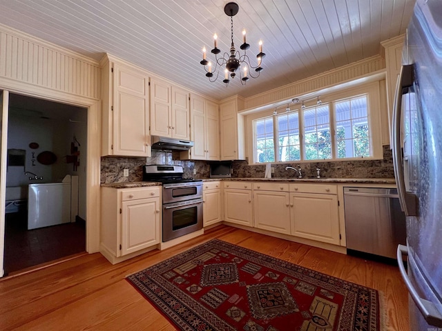 kitchen with light wood-type flooring, stainless steel appliances, sink, a notable chandelier, and hanging light fixtures