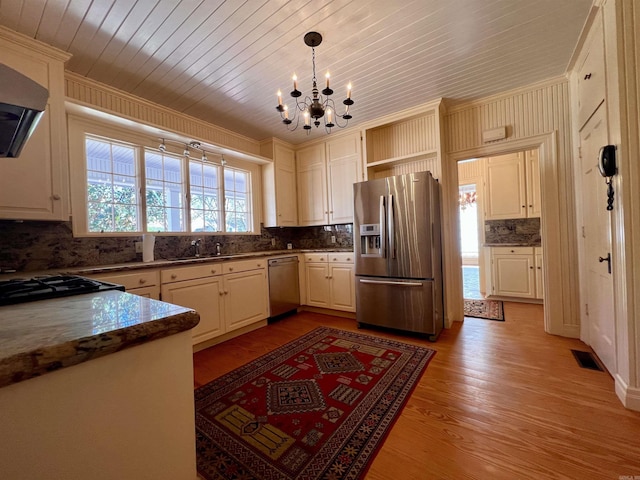 kitchen with ventilation hood, stainless steel appliances, crown molding, light hardwood / wood-style flooring, and hanging light fixtures