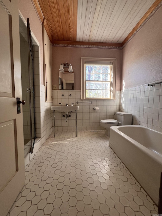 bathroom featuring a bidet, tile patterned floors, toilet, tile walls, and wood ceiling