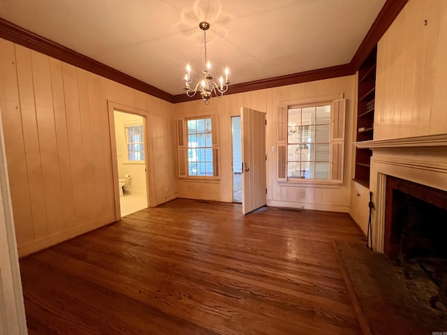 interior space featuring dark hardwood / wood-style flooring, ornamental molding, and a chandelier