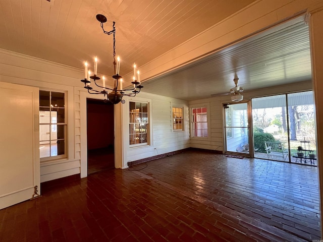 interior space with wooden walls, wooden ceiling, and ceiling fan with notable chandelier