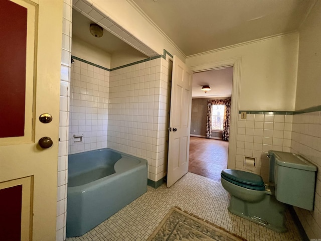 bathroom featuring tile patterned flooring, toilet, a bathtub, tile walls, and ornamental molding