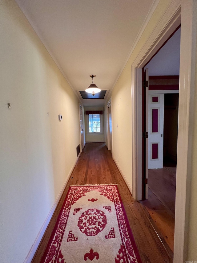 corridor with wood-type flooring and ornamental molding