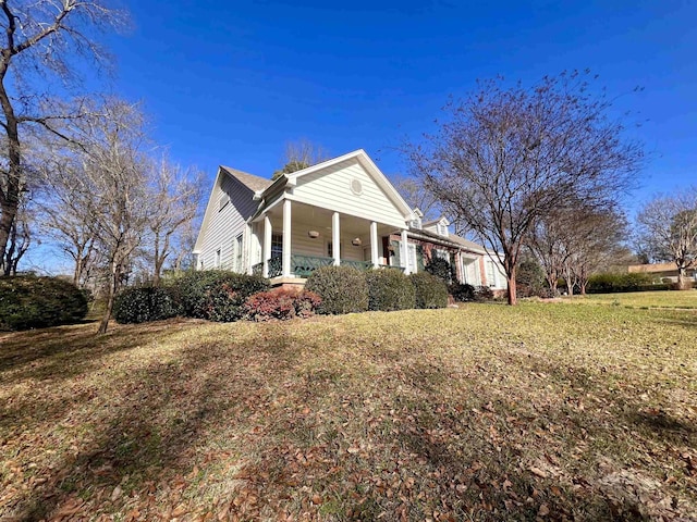 view of side of property with a porch and a lawn