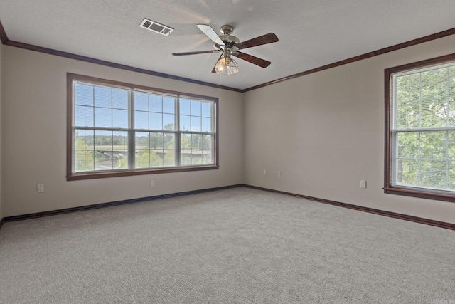 empty room with a textured ceiling, light colored carpet, ceiling fan, and ornamental molding