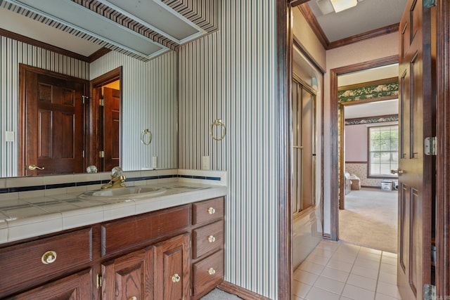 bathroom featuring tile patterned flooring, vanity, a shower with door, and ornamental molding