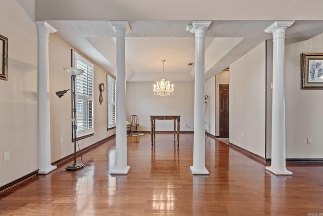 interior space with hardwood / wood-style floors, a notable chandelier, and a raised ceiling