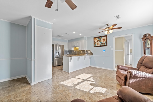 tiled living room with ceiling fan, crown molding, and sink