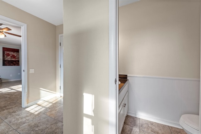 bathroom featuring vanity, ceiling fan, and toilet