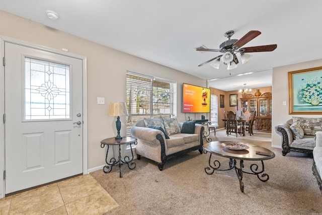 tiled living room featuring ceiling fan with notable chandelier