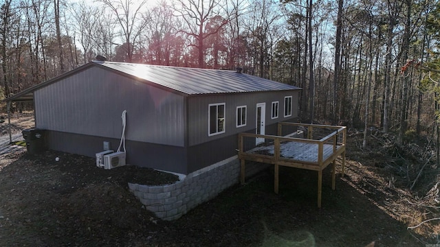 view of side of home featuring a wooden deck and ac unit