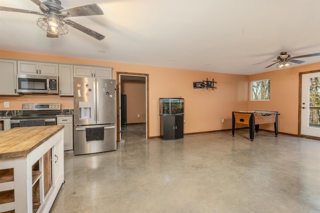 kitchen with wood counters, ceiling fan, gray cabinetry, and appliances with stainless steel finishes