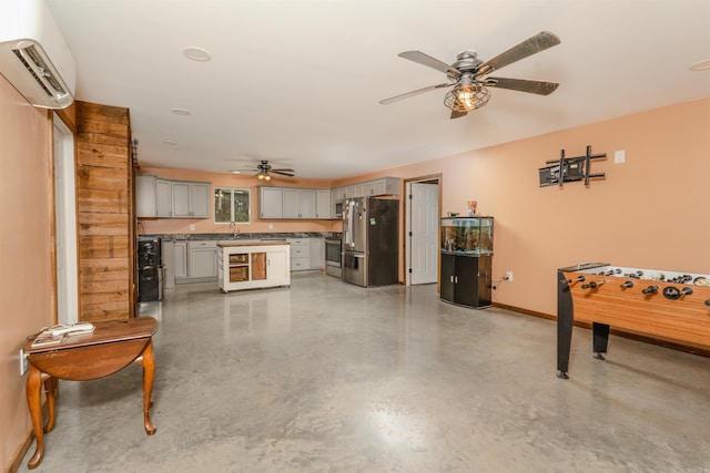 interior space featuring a wall mounted air conditioner, ceiling fan, and sink