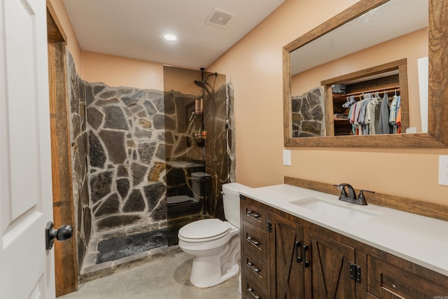 bathroom featuring a shower, vanity, and toilet