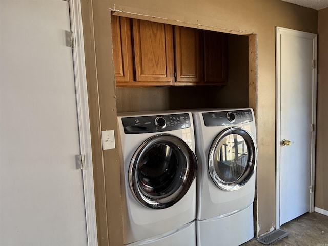 washroom featuring cabinets and separate washer and dryer