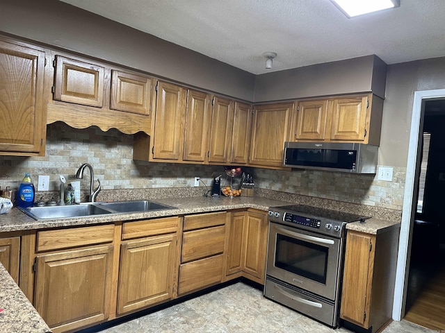 kitchen with decorative backsplash, sink, and stainless steel appliances