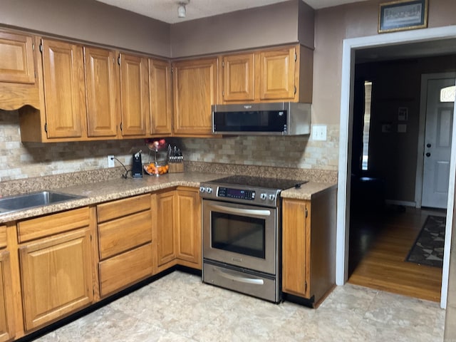 kitchen featuring decorative backsplash, sink, and stainless steel appliances