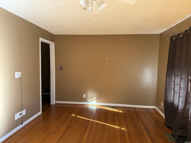 spare room with ceiling fan, dark hardwood / wood-style flooring, and a textured ceiling