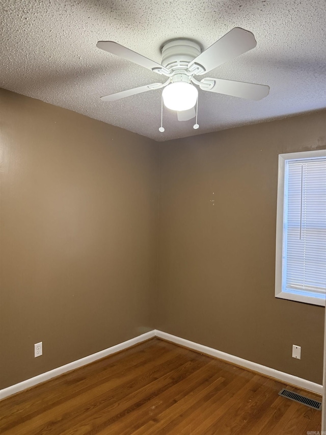 unfurnished room featuring ceiling fan, wood-type flooring, and a textured ceiling