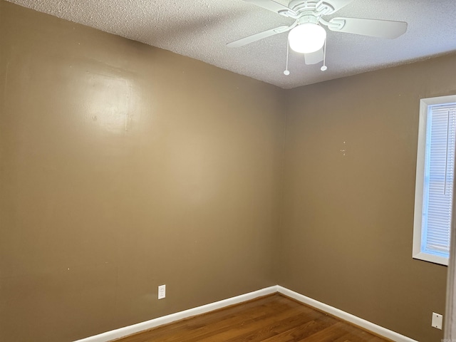 spare room featuring ceiling fan, wood-type flooring, and a textured ceiling