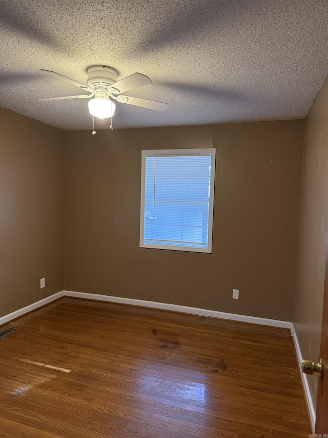 empty room with wood-type flooring, a textured ceiling, and ceiling fan