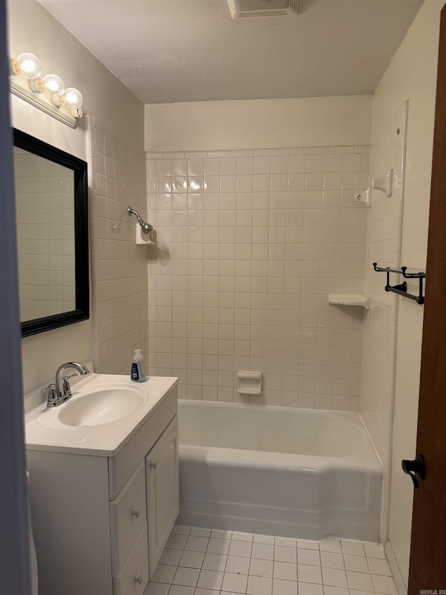 bathroom with tile patterned floors, vanity, and tiled shower / bath combo