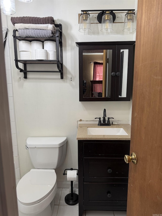 bathroom featuring toilet, vanity, and tile patterned floors