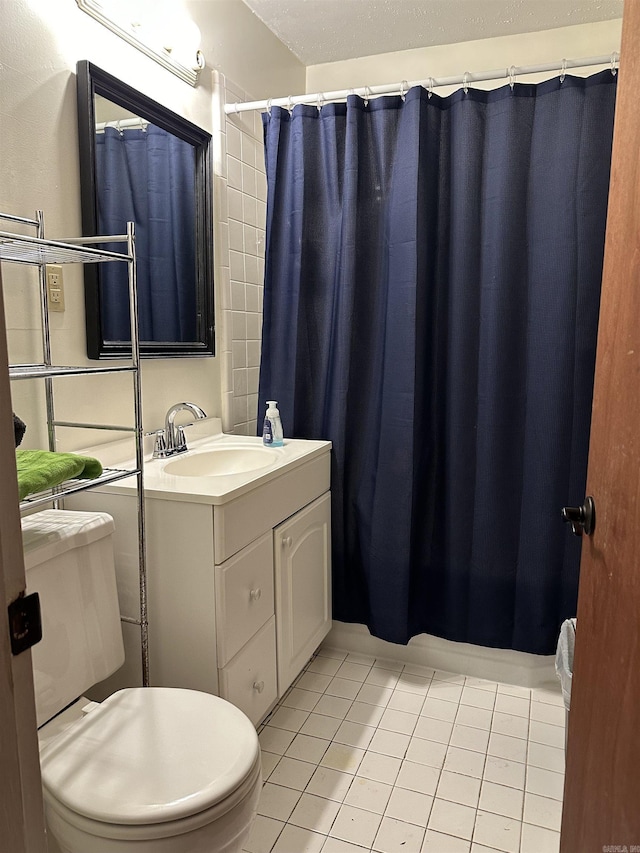 bathroom featuring tile patterned flooring, vanity, toilet, and walk in shower