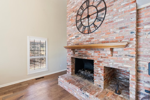 details with hardwood / wood-style floors and a brick fireplace