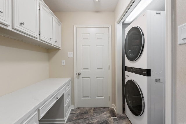 washroom featuring cabinets and stacked washer / drying machine