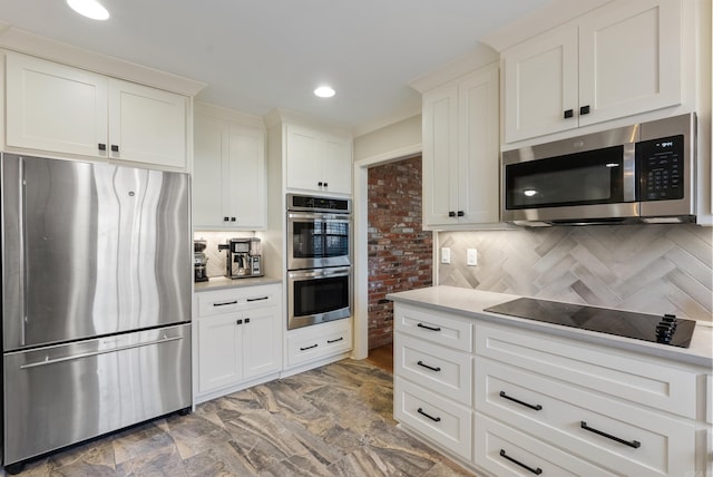 kitchen with white cabinetry, stainless steel appliances, and tasteful backsplash