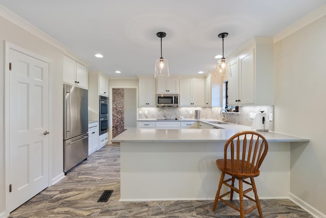 kitchen with kitchen peninsula, decorative backsplash, stainless steel appliances, sink, and white cabinetry