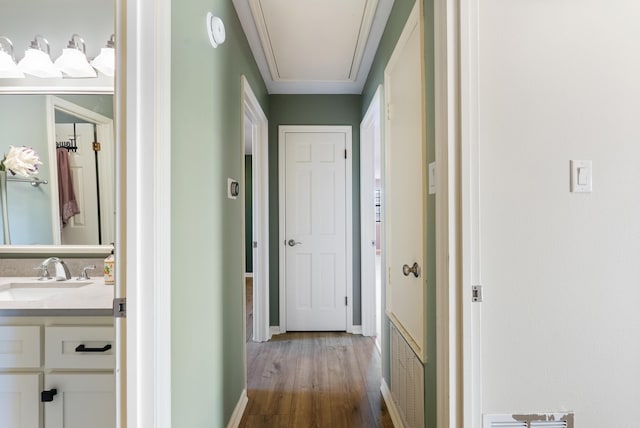 hallway with hardwood / wood-style floors and sink