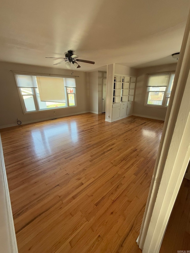 unfurnished living room featuring ceiling fan and light hardwood / wood-style flooring