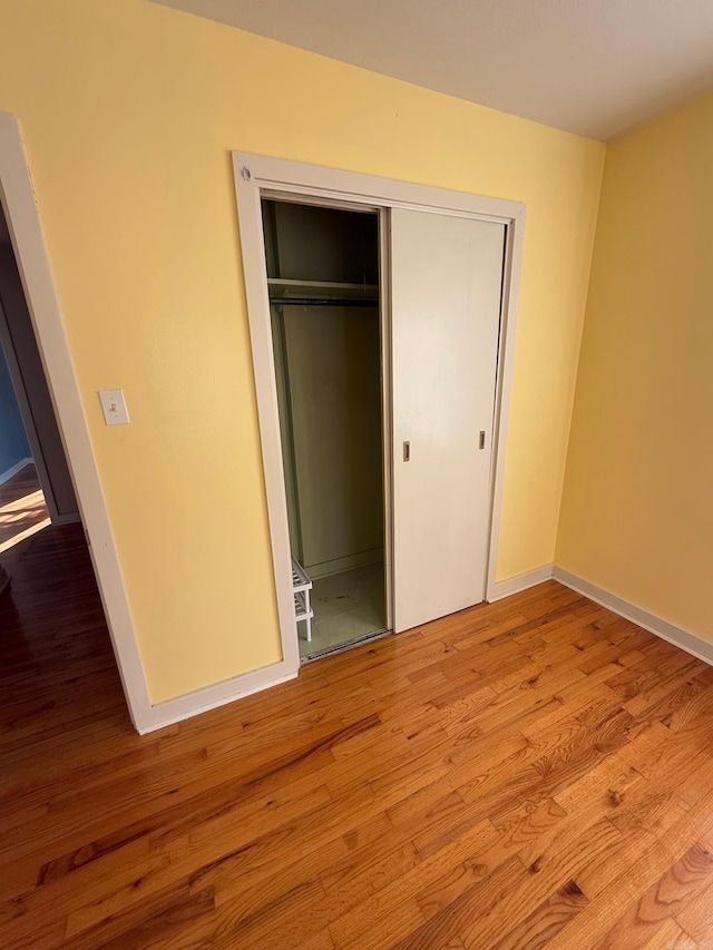 unfurnished bedroom with a closet and light hardwood / wood-style flooring