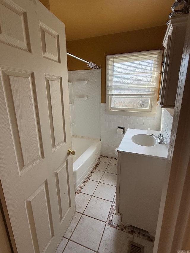 full bathroom featuring tile patterned floors, tub / shower combination, vanity, tile walls, and toilet