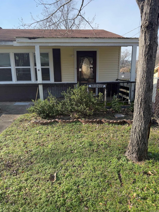 exterior space featuring covered porch and a lawn